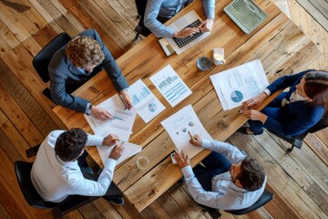 Poster - four professionals discussing strategies and analyzing data at a wooden conference table in a modern