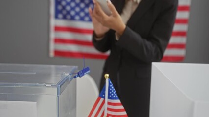 Poster - African american woman using smartphone in voting center with usa flag and ballot box.