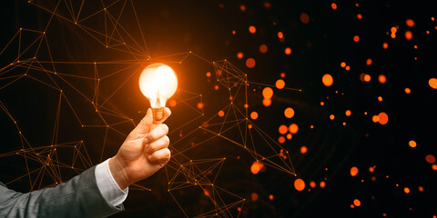 Poster - A hand holding a glowing light bulb against a dark background with orange bokeh lights and connected lines, representing a concept of innovation and ideas