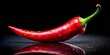 © LavaPixel - Fiery red chili pepper on black, culinary spice