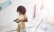 © peopleimages.com - Business woman, tablet and walking on stairs for communication, networking and check schedule. African person, tech and steps with social media, conversation and online meeting calendar for work