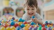 © Pual GotoMars - Happy child playing in a colorful ball pit, smiling and enjoying playtime in a cheerful, fun-filled environment at home or daycare.