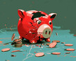 © M - Cracked red piggy bank with scattered coins and green background, symbolizing financial loss and savings depletion