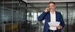 © Stock 4 You - Banner portrait of middle aged Latin or Indian businessman talking having call on smartphone with business partner, holding documents. Mature Hispanic man using mobile cellphone at work in office