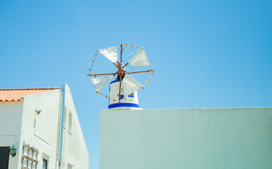 little Old restored small windmill in Aljezur, Portugal, against the blue sky