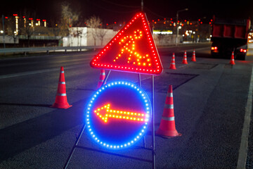 Wall Mural - Repair of the road with glowing signs at night.