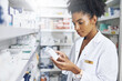 © peopleimages.com - Black woman, pharmacist and medicine box in clinic for product stock, ingredients and check information on label. Female person, list and reading pills for medical inventory, inspection and retail