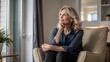 © mamo studios - Middle-aged woman sitting in chair by window, lost in thought, envisioning bright future at home