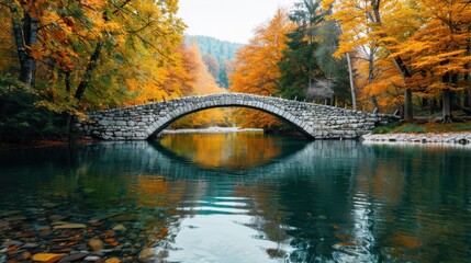  A calm river reflects the vibrant autumn foliage as it flows under an arched stone bridge, framed by the forest's golden and orange-hued leaves during the fall season.