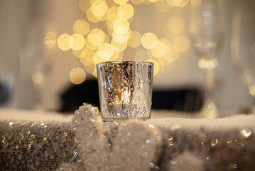 Gold candle on glitter surface with round bokeh background