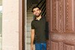 © AntonioDiaz - Man greets guests with a warm smile at his front door, creating a welcoming atmosphere