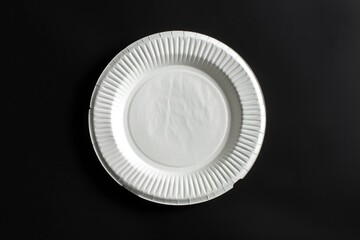 Aufkleber - A single white paper plate sits on a black background