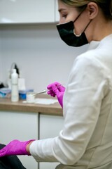 A beautician performs cosmetic procedures on a girl's face