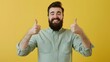 © Berkah - Young handsome man with beard over isolated yellow background with thumbs up because something good has happened.
