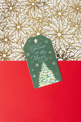 Wall Mural - christmas tag with message on gold foil florals and solid red paper background