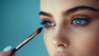 © best stock - Beautiful female eyes with bright blue make-up and brush