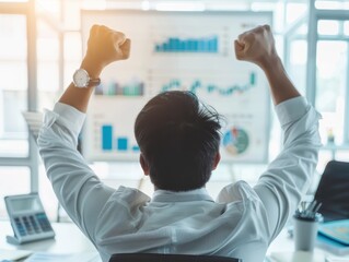 Poster - Rear view of a businessperson celebrating success in front of a screen with financial charts in a modern office setting.