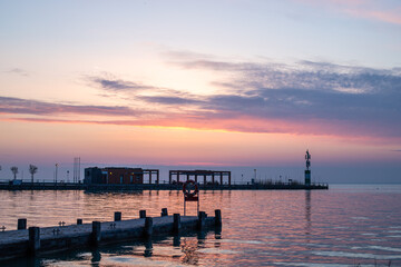 Wall Mural - Sunrise on the shore and harbor of a lake in summer. Colorful sky with a wide view of the Horiont. Nature landscape at Tihany marina, Balaton, Lake Balaton, Siófok, Hungary