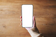 © Farknot Architect - Top view mockup image of a woman holding mobile phone with blank desktop screen