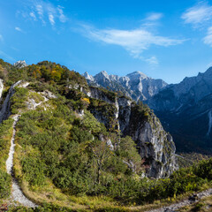 Wall Mural - Sunny colorful autumn alpine scene. Peaceful rocky mountain view from hiking path near Almsee lake, Upper Austria.