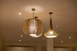 © Rattanachat - Three light fixtures hanging from the ceiling, one of which is a large