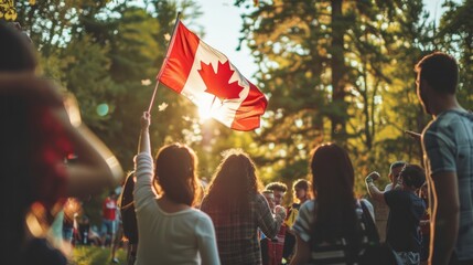 Canadian Pride: A young woman proudly holds the Canadian flag high, backlit by the setting sun at a vibrant outdoor gathering.  The image evokes a sense of national unity and celebration. 