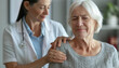 © ЮРИЙ ПОЗДНИКОВ - A doctor consoles an elderly woman by placing his hand on her shoulder while talking