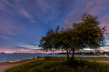 Wall Mural - The background of the sea by the evening sea, with natural beauty (sea water, rocks, sky) and fishermen are fishing by the river bank, is a pleasure during travel.