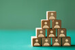 © CozyDigital - Personnel search. Creating the perfect team. Wooden cubes with icons of people stand on top of each other.