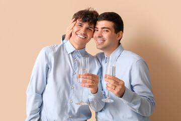 Poster - Married gay couple with glasses of champagne on beige background