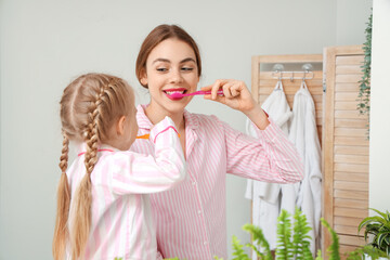 Sticker - Young mother and her little daughter brushing teeth in bathroom