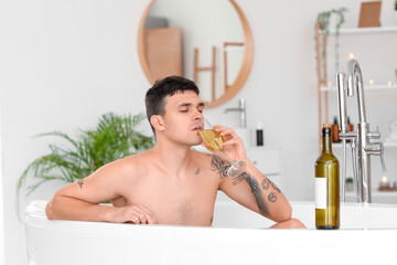 Poster - Young man with champagne taking bath at home