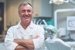 © IULIIA SAVINA - Smiling mature dentist man in his office