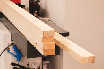 Poster - A stack of wood is being cut by a machine