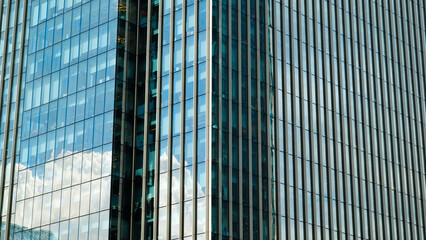 A tall building with many windows and a cloudy sky in the background