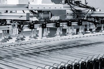Poster - A machine with many parts and wires is in motion. The machine is used to make something. The image has a sense of motion and activity
