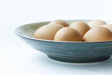 Wall Mural - Close-up of raw eggs with light orange color on blue dish and white floor, South Korea
