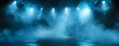 © Simon - Empty dark stage with spotlights, fog and smoke in a theatre. Mysterious room with concrete floor. Festival, event, concert, dramatic atmosphere concept.