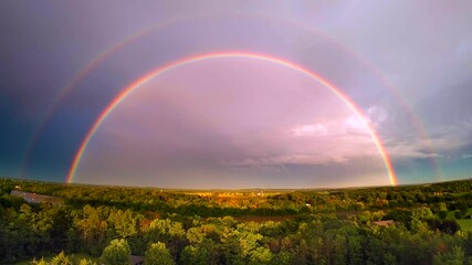 Wall Mural - Colorful rainbow over scenic rural landscape with muddy river after heavy rains, aerial view.
