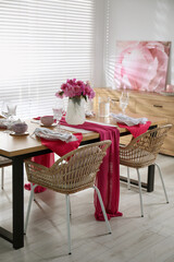 Poster - Pink peonies on table with beautiful setting and rattan chairs in dining room