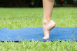 © Tirso Lecointere - Close-up of woman feet stepping on the yoga mat. Yogist instructor doing yoga exercise in the park. Stretching and meditating in the outdoors.
