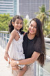 © Masakazu Tokashiki - A 30-something Indian Malaysian mother wearing a miniskirt and her 5-year-old daughter in a white dress spending time joyfully on a bridge in City Centre, Kuala Lumpur, Malaysia.