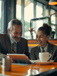 © MZacky - Business colleagues sharing a laugh over a tablet. Male executive and young female employee.