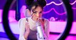 © CineLens2024/peopleimages.com - Woman, microphone and influencer with social media streaming and ASMR for podcast. Home studio, creative and content creator with neon lights, online platform and streamer with audio and voice work