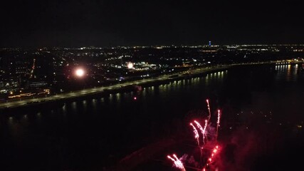 Wall Mural - Drone flight through holiday fireworks above water with reflection on the black sky background. Montreal.