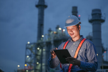 Engineering man working with digital tablet on power plant working site at night time.