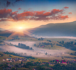 Poster - Foggy summer sunrise in Lozaschina village. Misty morning scene of Carpathian mountains, Ukraine, Europe. Dramatic dawn scene of mountain valley. Beauty of countryside concept background..