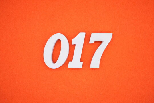 The numbers are made of white painted wood. Placed on the floor was orange paper.