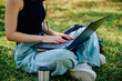 © Cavan Images - University student typing on laptop outdoors