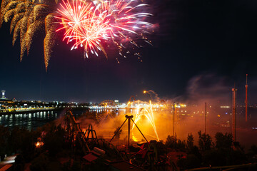 Wall Mural - Holiday fireworks above water with reflection on the black sky background